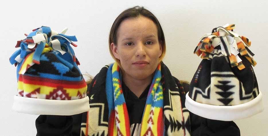 GED student displays hats and scarves she made.